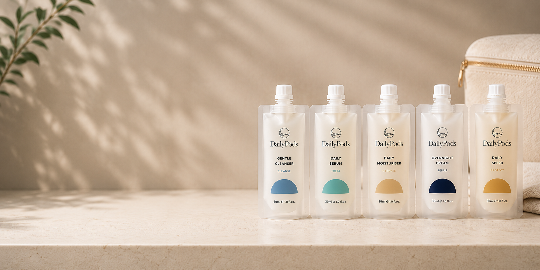 DailyPods™ travel skincare pouches arranged beside a cream travel bag